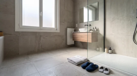 Salle de bain familiale moderne avec carrelage grand format, illustrant la question de sa durabilite dans le temps