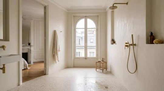 Douche de plain-pied dans une salle de bain parisienne au sol carrelé continu, créant une sensation d'espace agrandi