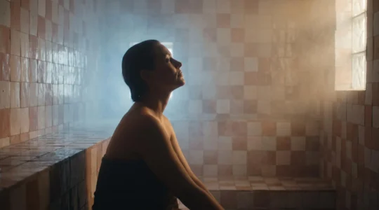 Personne détendue dans la vapeur d'un hammam domestique à la lumière douce, illustrant le dilemme entre bien-être et bénéfice thérapeutique réel